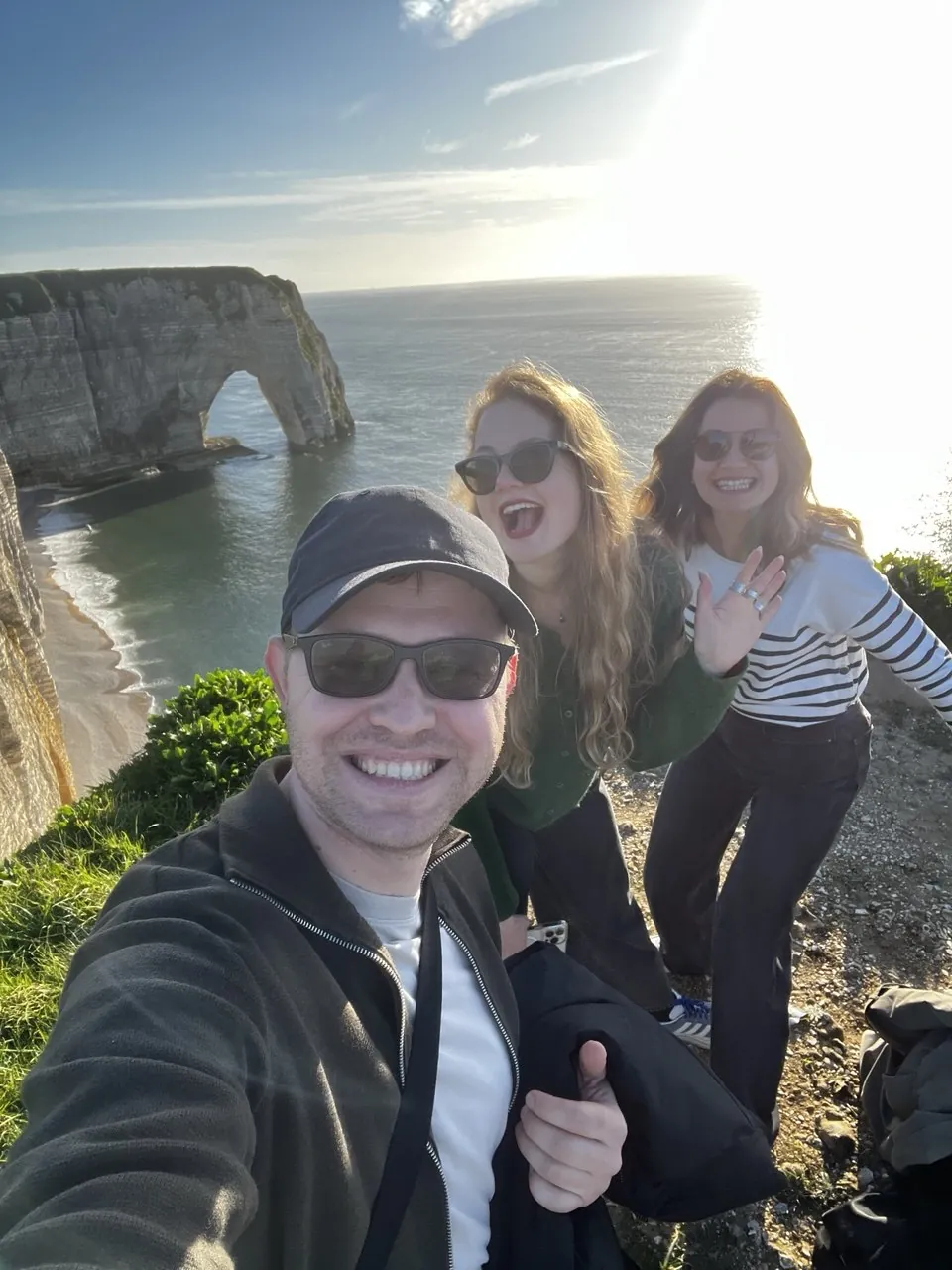 Three smiling ProTours guests at the Étretat cliffs